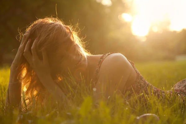 Trendiga Hipster smal tjej avkopplande på gräset i parken sommar solnedgång — Stockfoto