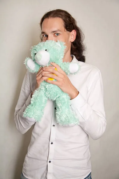 Schöner romantischer Mann mit Teddybär-Geschenk auf weißem Hintergrund isoliert — Stockfoto