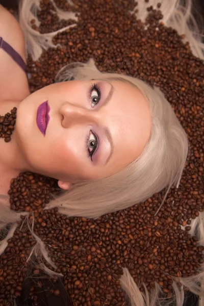 Piękna Blondynka Kobieta, leżąc z ziaren kawy widok z góry — Zdjęcie stockowe
