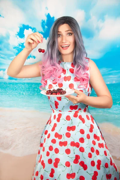 Alegre jovem pin up menina comer doce cereja de pé sozinho — Fotografia de Stock