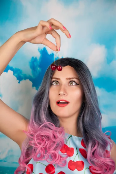 Alegre jovem pin up menina comer doce cereja de pé sozinho — Fotografia de Stock