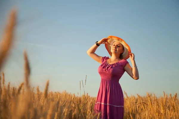 황금 보 리 밭에 서 있는 모자와 예쁜 더하기 크기 여자 — 스톡 사진