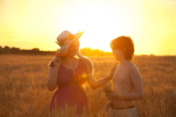 Anne ve çocuk günbatımı buğday alanında — Stok fotoğraf
