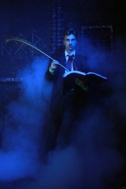 duman siyah arka plan üzerinde duran yakışıklı mistik yazar