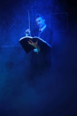 duman siyah arka plan üzerinde duran yakışıklı mistik yazar