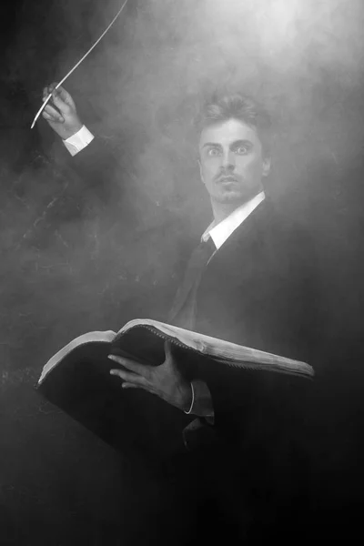 Красивый мистический писатель, стоящий на черном фоне в дыму — стоковое фото