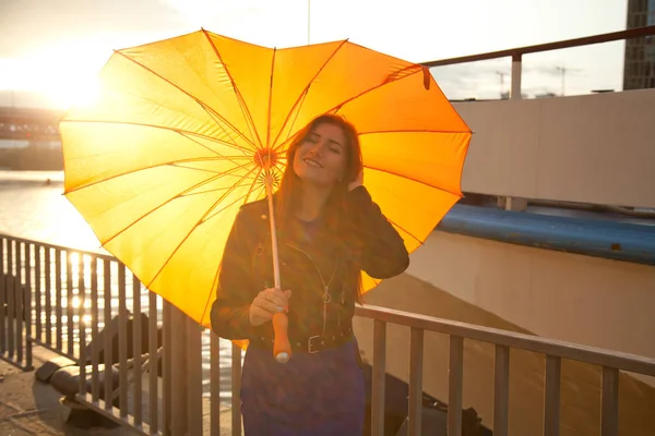 Bonita joven pelirroja con paraguas naranja corazón grande en la calle de la ciudad — Foto de Stock
