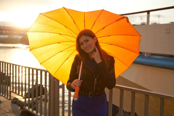 Bonita joven pelirroja con paraguas naranja corazón grande en la calle de la ciudad — Foto de Stock