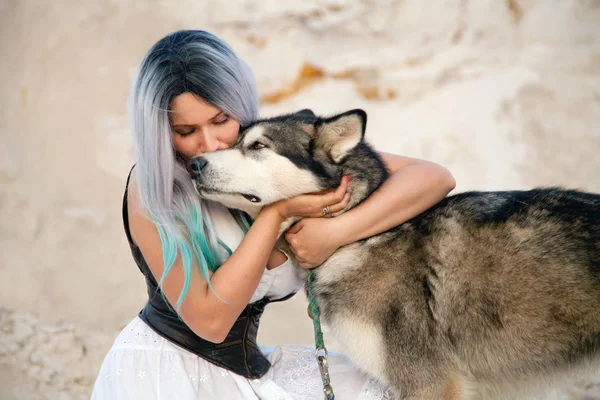 美丽的年轻女老板和她可爱的快乐小狗阿拉斯加雪橇犬在沙漠中猎物的白色沙滩 — 图库照片