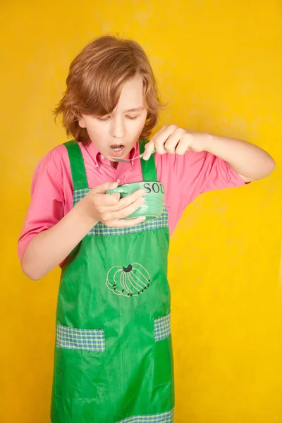 Ωραίο είδος έφηβο, τρώει σούπα σε φόντο κίτρινο studio μόνο — Φωτογραφία Αρχείου