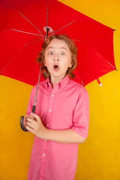Χαριτωμένο παιδί με κόκκινη ομπρέλα φωτεινό σε κίτρινο φόντο μόνος — Φωτογραφία Αρχείου