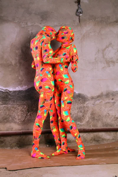 2 つのオレンジ色の全身タイツ フェチ女の子の演奏 — ストック写真