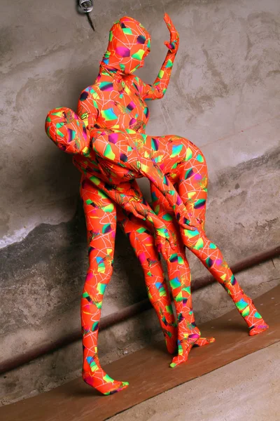 2 つのオレンジ色の全身タイツ フェチ女の子の演奏 — ストック写真