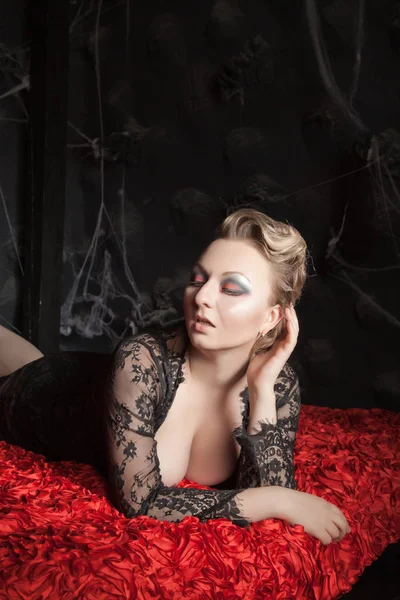 Sexy gadis muda berpose di tempat tidur merah saja — Stok Foto