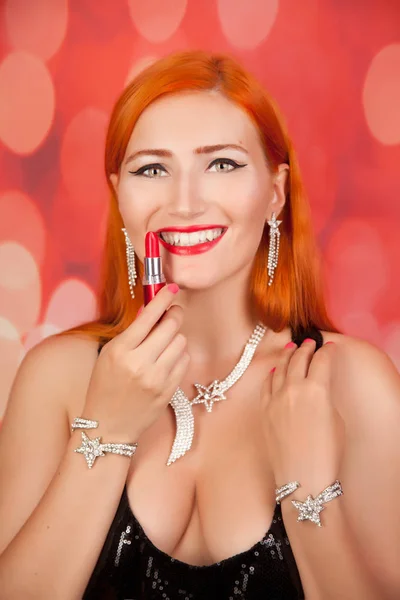 Mode schöne rothaarige Mädchen mit rotem Lippenstift auf rotem Hintergrund — Stockfoto