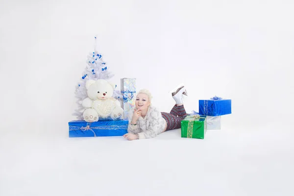 Bonita xmas cabelo curto mulher loira deitado com caixas de presente e árvore de natal no fundo branco isolado — Fotografia de Stock