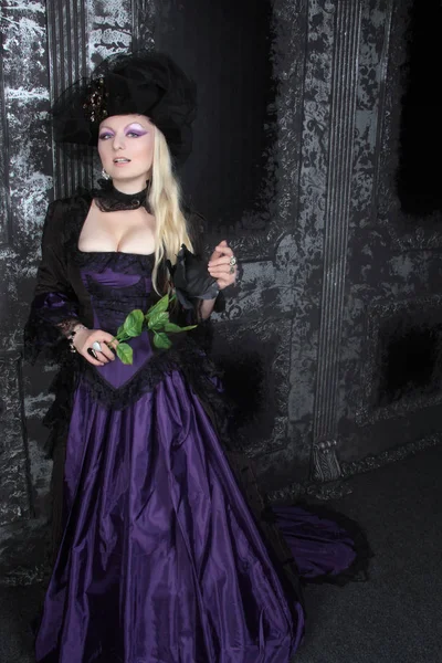 Wanita cantik berambut pirang mengenakan sejarah ungu panjang gaun — Stok Foto
