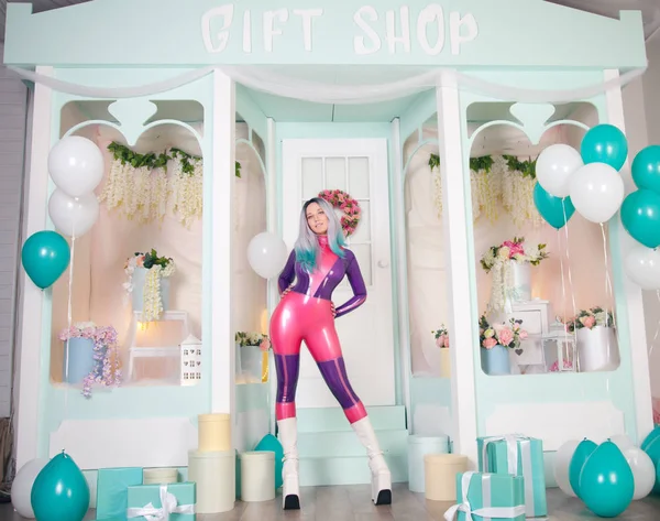 Bonita chica de anime con traje de muñeca de goma de látex y posando cerca de la tienda de regalos blanco lindo con globos de aire y regalos y regalos para Navidad y año nuevo —  Fotos de Stock