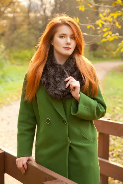 Menina bonita outono com cabelo vermelho no parque amarelo sozinho — Fotografia de Stock