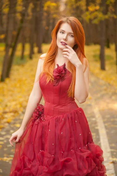 Menina bonita outono com cabelo vermelho no parque amarelo sozinho — Fotografia de Stock