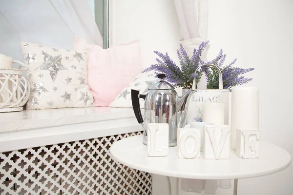 Carino davanzale bianco accogliente con comodi cuscini morbidi e un tavolino vicino — Foto Stock