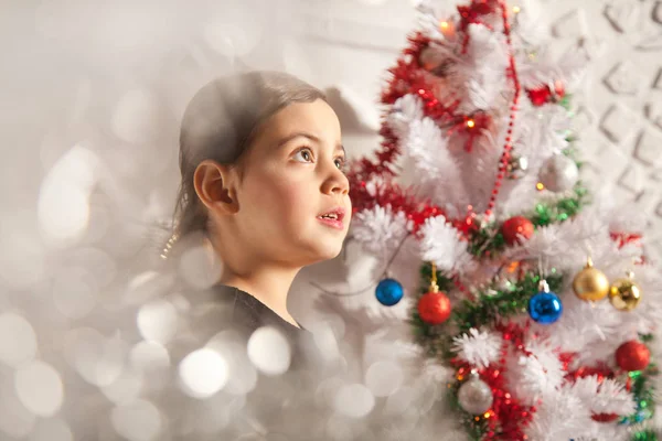 Menina criança muito emocional com árvore de natal — Fotografia de Stock