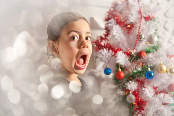 Menina criança muito emocional com árvore de natal — Fotografia de Stock