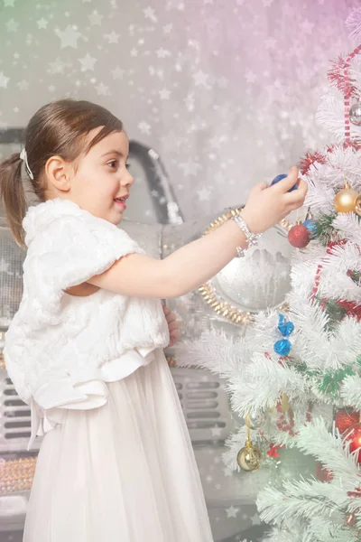 Menina criança muito emocional com árvore de natal — Fotografia de Stock