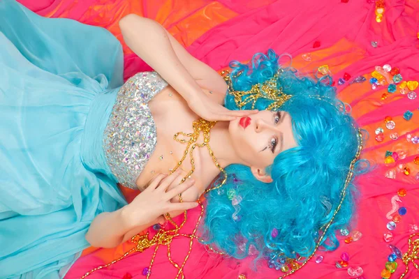 Bela menina brilhante feliz com cabelo azul deitado sozinho no vestido de noite longa com strass vista superior — Fotografia de Stock