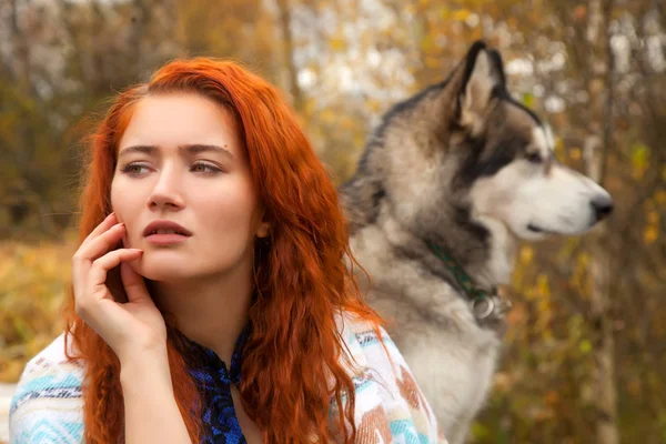 Pretty Woman s červenými vlasy s její obrovský pes malamut — Stock fotografie
