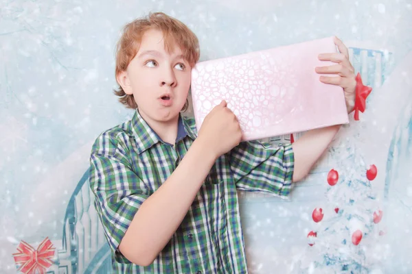 Нещасний емоційний розгніваний хлопчик з різдвяною подарунковою коробкою один — стокове фото