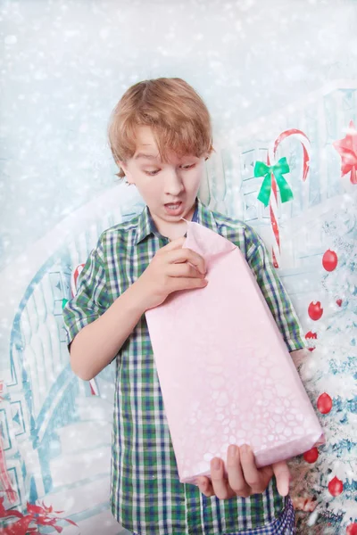 Bonito feliz caucasiano criança menino de pé com caixa de presente e abrindo presentes com boas emoções — Fotografia de Stock