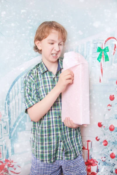 Нещасний емоційний розгніваний хлопчик з різдвяною подарунковою коробкою один — стокове фото
