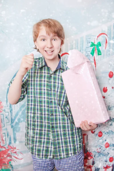 Милий щасливий білий хлопчик, що стоїть з подарунковою коробкою і відкриває подарунки з хорошими емоціями — стокове фото