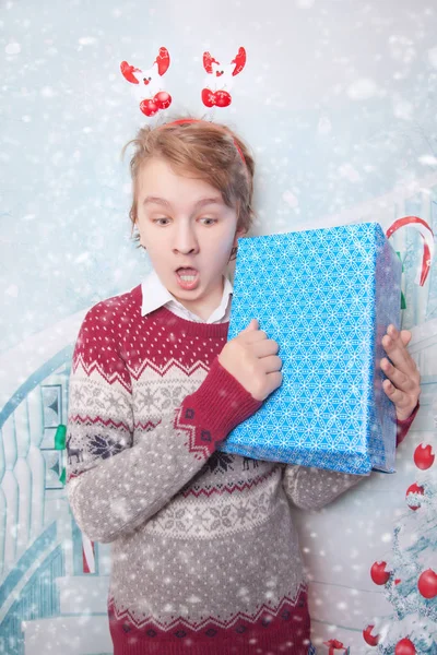 Щасливий хлопчик у різдвяному светрі та синій подарунковій коробці — стокове фото