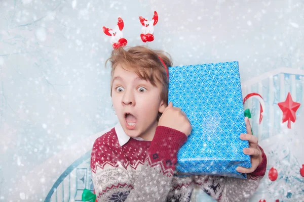 Bonito engraçado feliz menino ouvindo sua caixa de presente de Natal — Fotografia de Stock