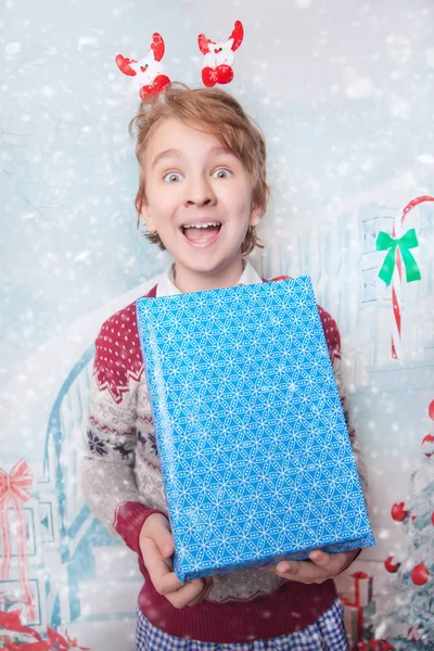 Lycklig pojke ler och skrattar med nyår jul presenterar — Stockfoto