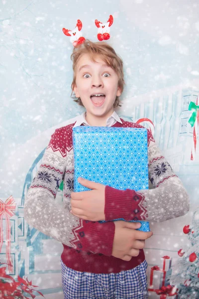 Menino feliz jovem sorrindo e rindo com presentes de Natal de Ano Novo — Fotografia de Stock