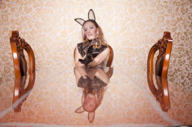 güzel kız siyah dantel tavşan maskesi, ok ve içkiyle yalnız bir masada oturan guipure boyun korse deri kısa eldiven