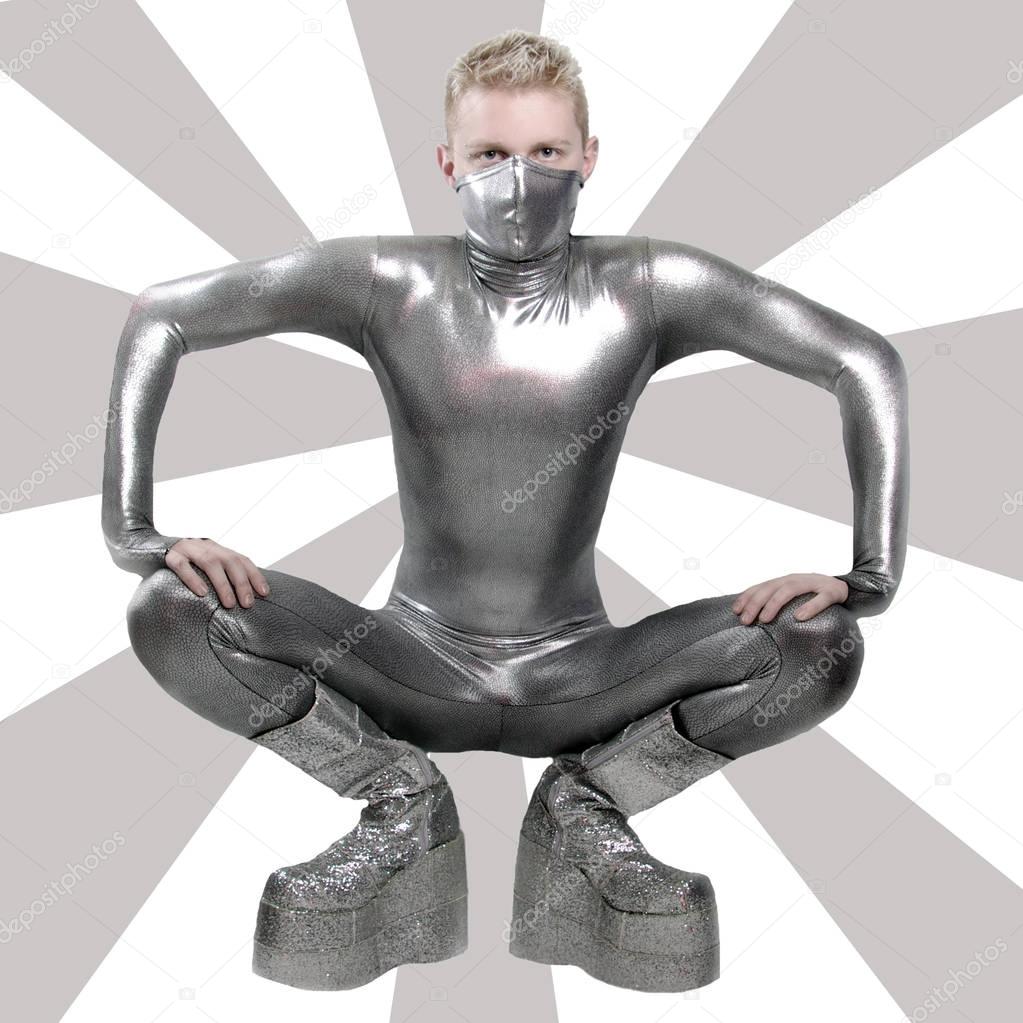 trendy guy dressed in a tight latex suit and platform boots posing in Studio on white background alone