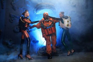 lateks lastik fetiş catsuits ve yüksek topuklu kadınlar metresleri ile poz tarihi dalış retro kostüm giyinmiş adam