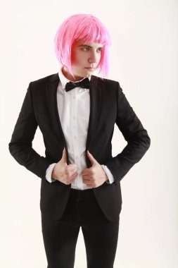 takım elbise ve pembe kadınlar peruk beyaz arka planda tek başına duran şık ve komik genç adam