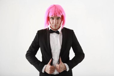 takım elbise ve pembe kadınlar peruk beyaz arka planda tek başına duran şık ve komik genç adam