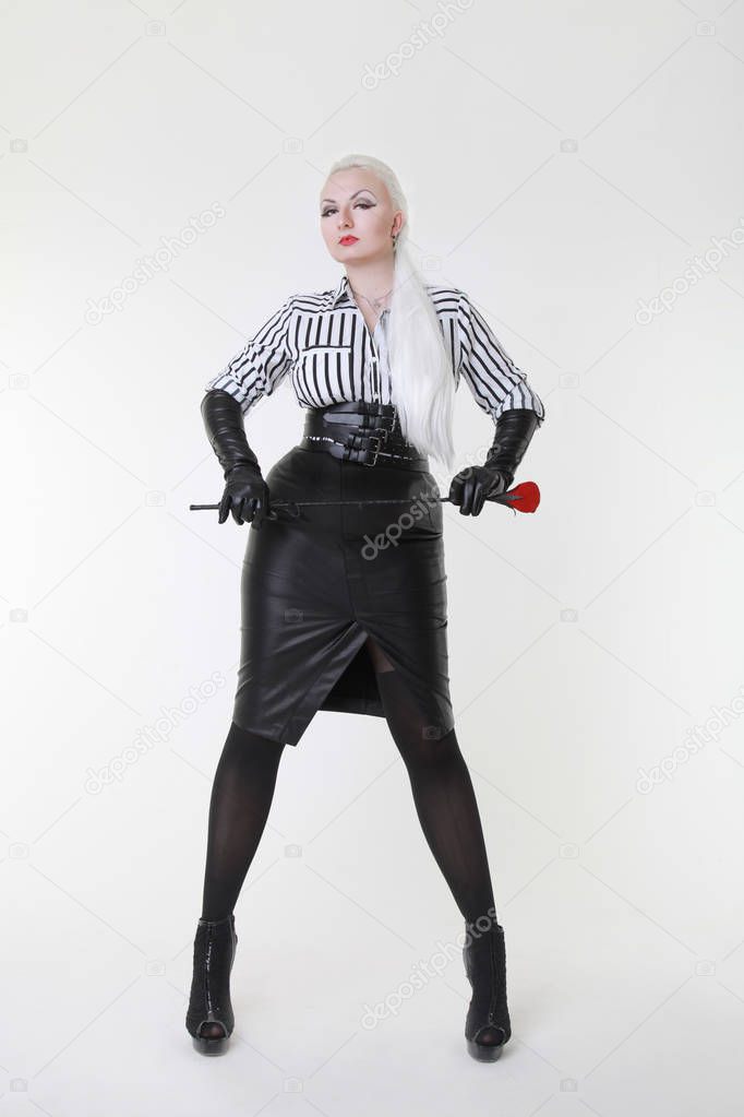 cruel fetish fashion mistress woman standing with bdsm riding crop alone on white background