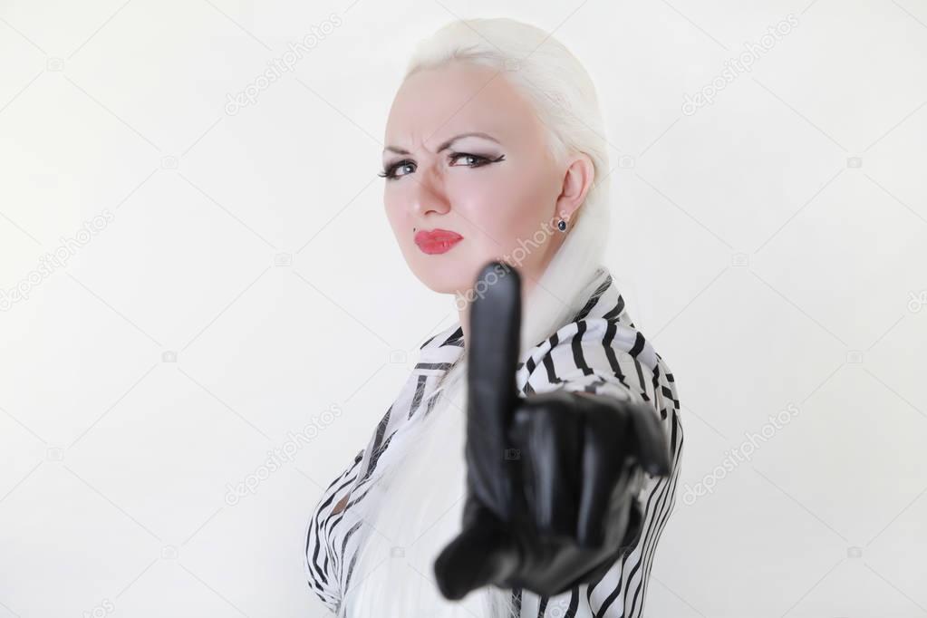 adult platinum blonde woman with unhappy cruel face shows stop symbol on white background