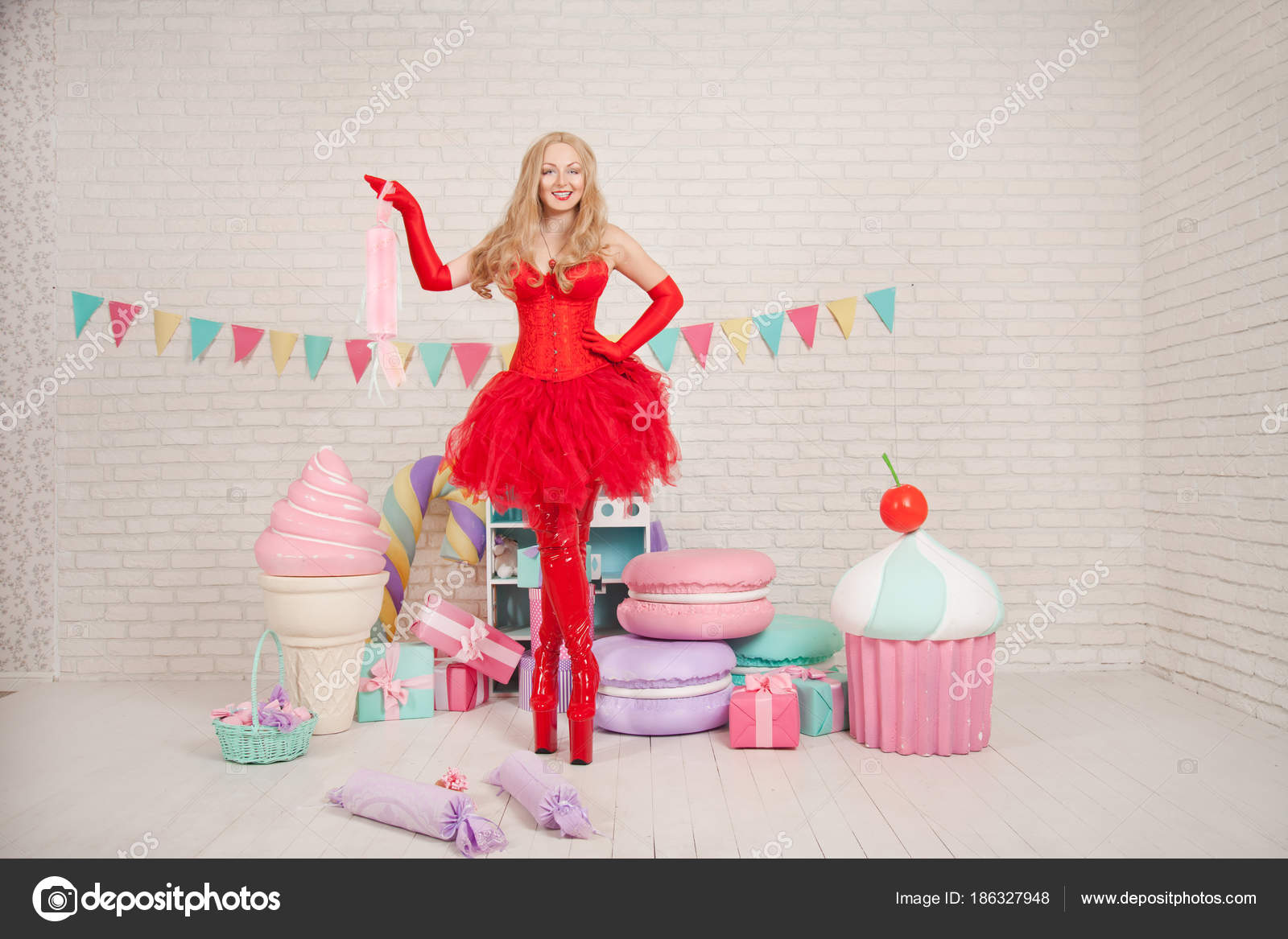 Bela modelo com maquiagem criativa está posando com um bolo gigante