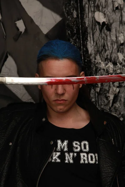 Hombre de moda pelo azul con espada sangrienta sobre fondo oscuro —  Fotos de Stock