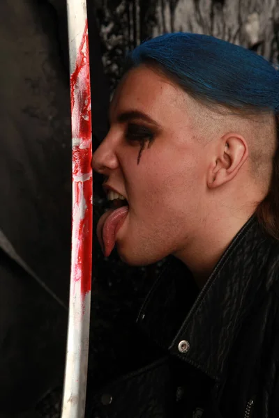 Azul cabelo moda cara com espada sangrenta no fundo escuro — Fotografia de Stock