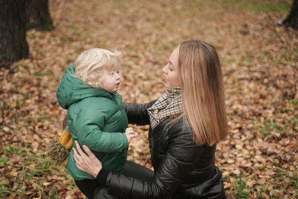 mom wears a hat to a child on the street. Portrait of cheerful little baby having fun with trendy mom outdoor