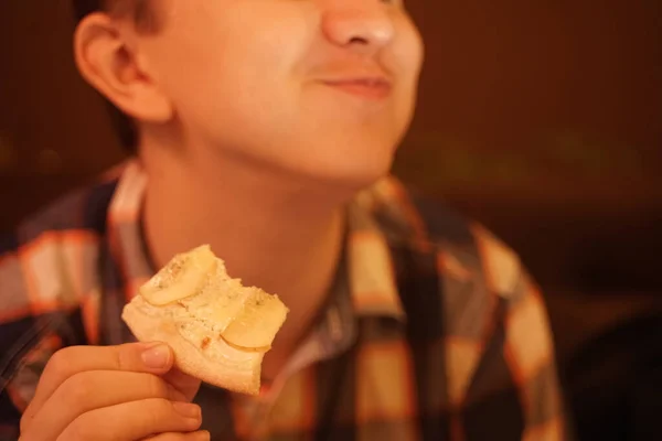 Dospívající chlapec jí pizzu a užívá si ji, detailní záběr těší a vychutnává. — Stock fotografie